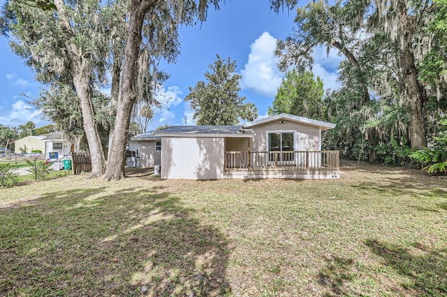 rear view of house with a deck and a lawn