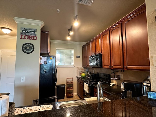 kitchen featuring kitchen peninsula, black appliances, ornamental molding, and dark stone counters