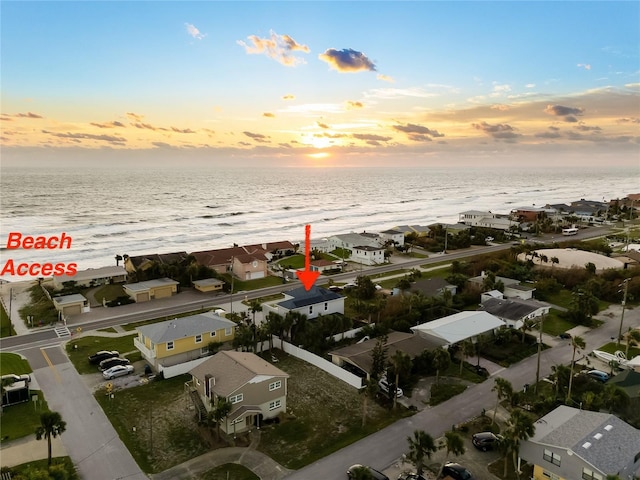 aerial view at dusk featuring a water view