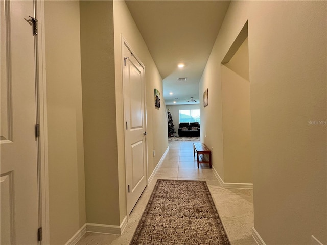 hallway featuring baseboards, visible vents, and recessed lighting