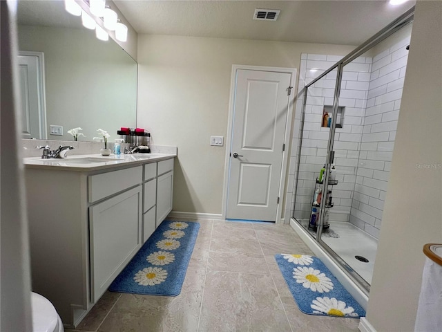 bathroom featuring an enclosed shower, vanity, and tile patterned flooring