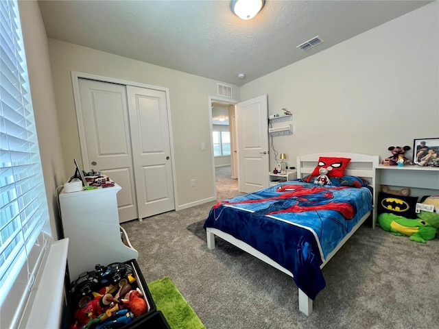 bedroom with carpet, a closet, and a textured ceiling