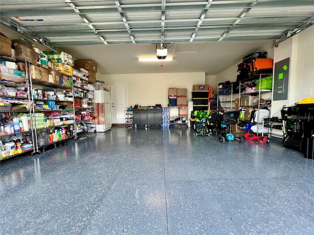 garage with a garage door opener, white fridge, and electric panel