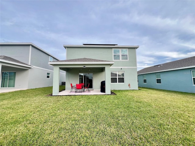 back of property featuring a lawn and a patio