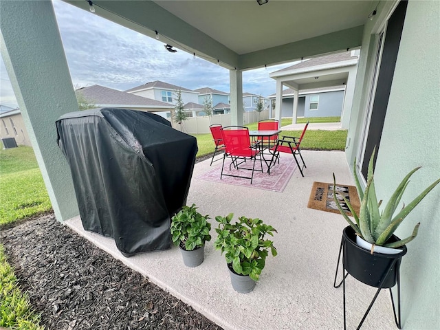 view of patio featuring outdoor dining space, fence, and area for grilling