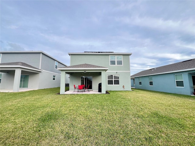 back of property with a patio, a yard, roof with shingles, and stucco siding