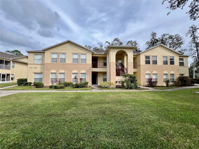 view of front of home with a front lawn and a balcony