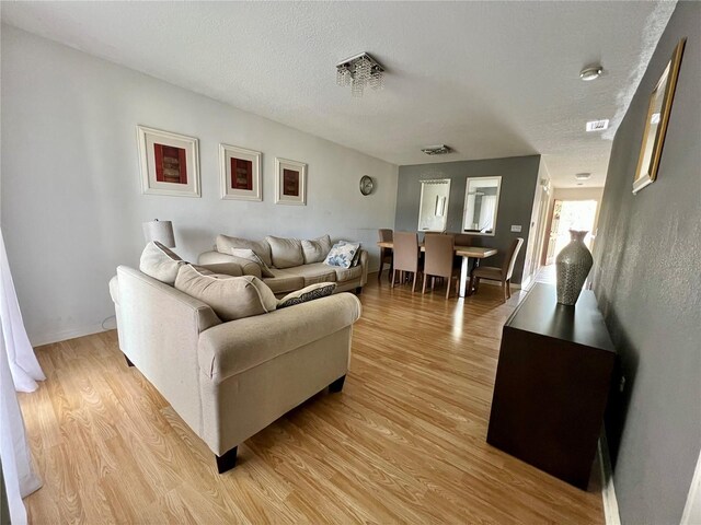 2878 Club Cortile Cir Unit A, Kissimmee, FL 34746 - living room with a textured ceiling, baseboards, and light wood finished floors