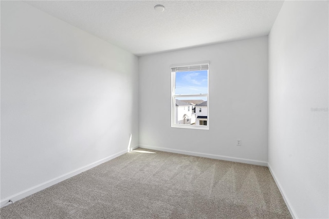 carpeted empty room featuring a textured ceiling