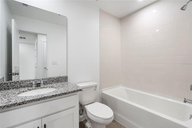 full bathroom featuring vanity, tiled shower / bath, and toilet