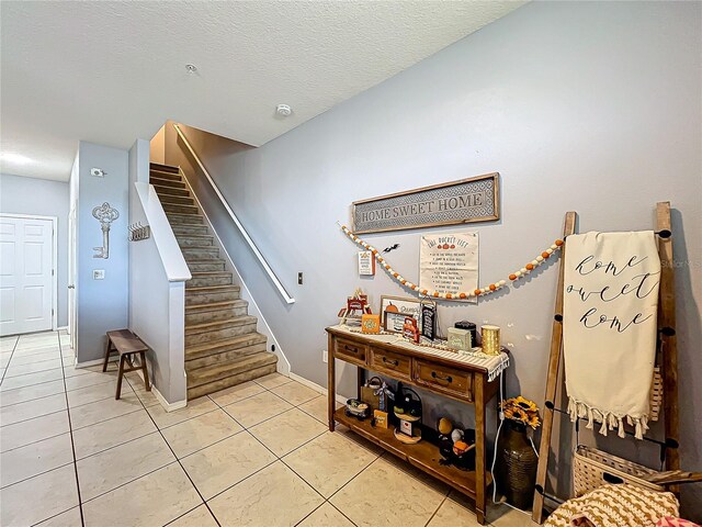 staircase with tile patterned floors and a textured ceiling