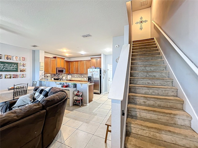 staircase featuring tile patterned floors and a textured ceiling