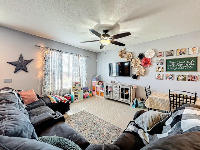 living room with ceiling fan, a textured ceiling, and light tile patterned floors