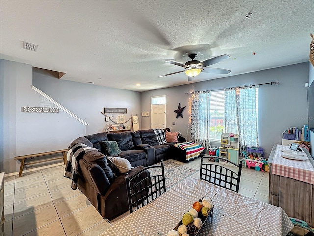 tiled living room with a textured ceiling and ceiling fan