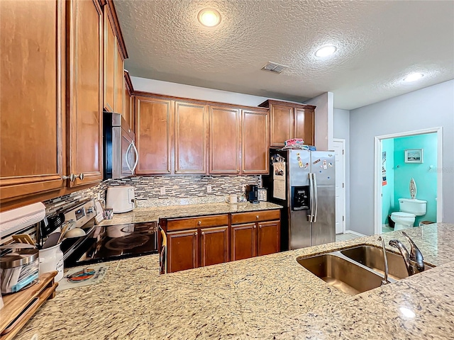 kitchen featuring stainless steel appliances, a textured ceiling, sink, and tasteful backsplash