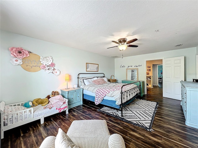 bedroom with dark hardwood / wood-style floors, a textured ceiling, and ceiling fan