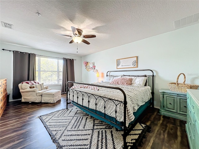 bedroom with dark hardwood / wood-style floors, a textured ceiling, and ceiling fan