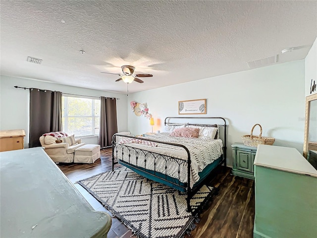 bedroom featuring a textured ceiling, dark wood-type flooring, and ceiling fan