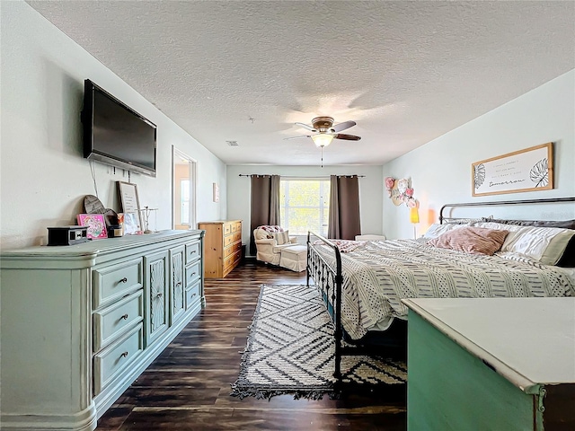 bedroom with a textured ceiling, dark hardwood / wood-style floors, and ceiling fan