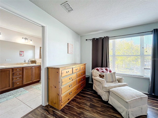 sitting room featuring a textured ceiling, sink, and hardwood / wood-style floors