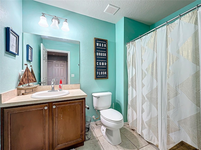 bathroom featuring toilet, tile patterned flooring, curtained shower, vanity, and a textured ceiling