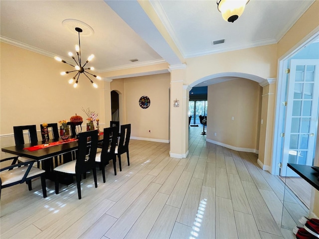 dining area featuring crown molding, light hardwood / wood-style floors, and a notable chandelier