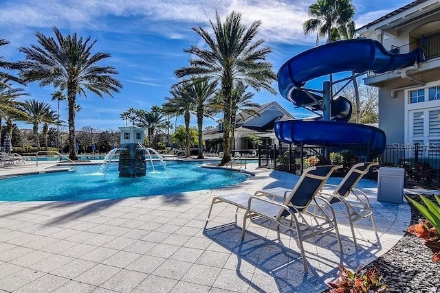 view of swimming pool with pool water feature and a water slide