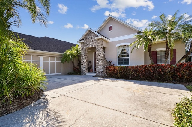 view of front of property with concrete driveway, an attached garage, and stucco siding