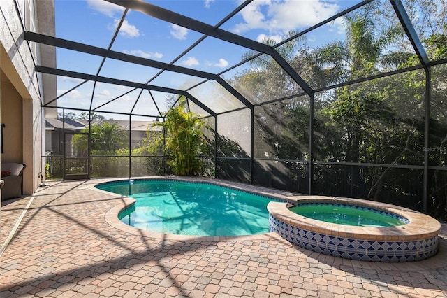 view of pool featuring glass enclosure, a patio area, and a pool with connected hot tub