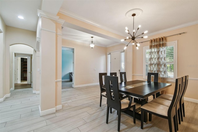 dining area with arched walkways, ornamental molding, baseboards, and wood tiled floor