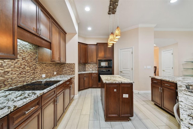 kitchen with a center island, pendant lighting, tasteful backsplash, light stone countertops, and black appliances