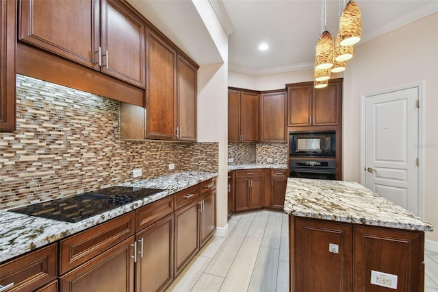 kitchen featuring light stone countertops, backsplash, a center island, black appliances, and decorative light fixtures