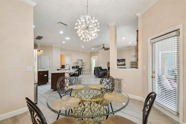 dining room featuring ceiling fan with notable chandelier, ornamental molding, plenty of natural light, and visible vents