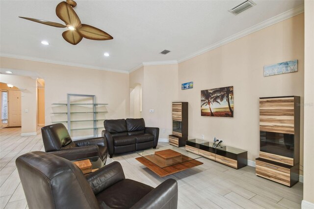 living room with a ceiling fan, visible vents, arched walkways, and crown molding