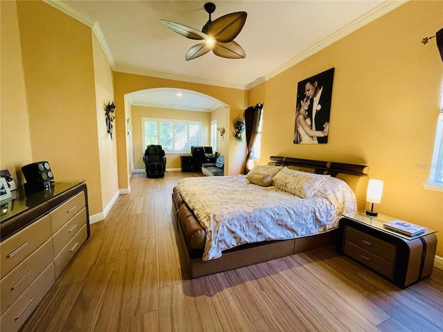 bedroom featuring arched walkways, crown molding, ceiling fan, wood finished floors, and baseboards