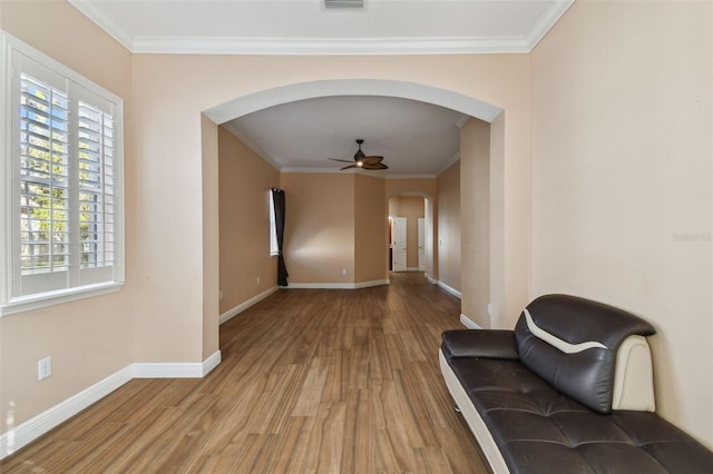 unfurnished room featuring a ceiling fan, arched walkways, baseboards, and wood finished floors