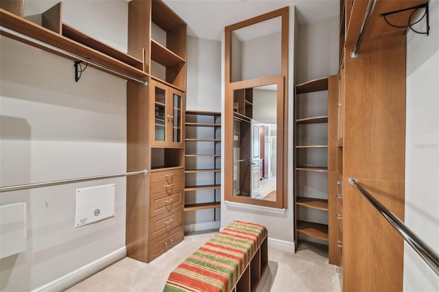 walk in closet featuring light colored carpet