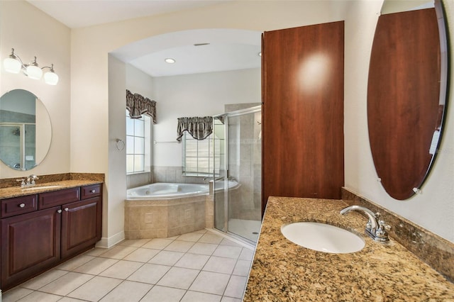 bathroom with a bath, tile patterned flooring, two vanities, and a sink