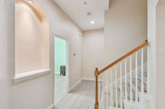 hall featuring light wood-type flooring, stairway, baseboards, and recessed lighting