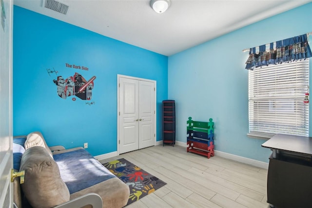 interior space with light wood-style floors, a closet, visible vents, and baseboards