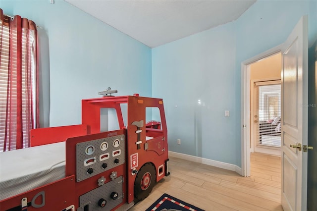 bedroom with light wood-style flooring and baseboards