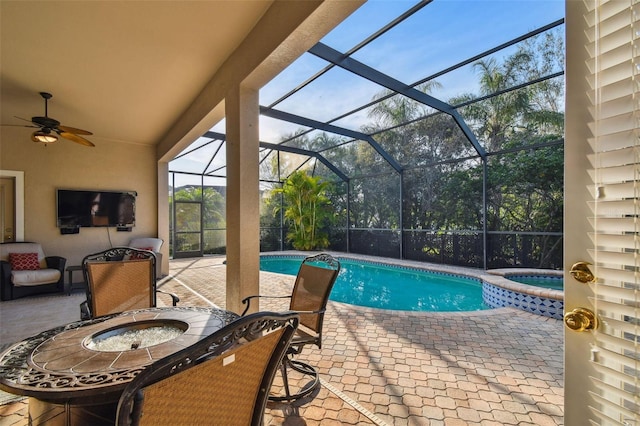 view of swimming pool featuring ceiling fan, a patio, a lanai, and a pool with connected hot tub