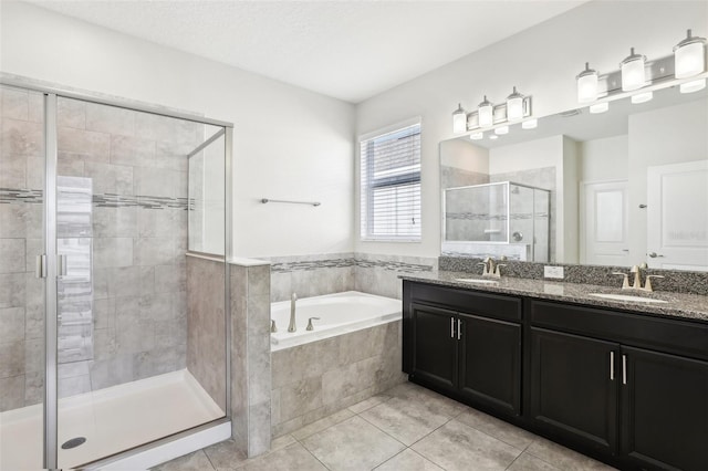 bathroom with tile patterned flooring, vanity, a textured ceiling, and independent shower and bath