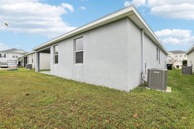 rear view of property featuring a lawn and central air condition unit