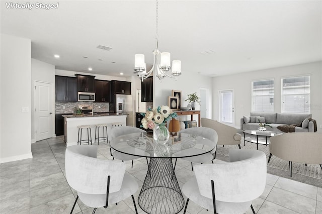 tiled dining area featuring an inviting chandelier