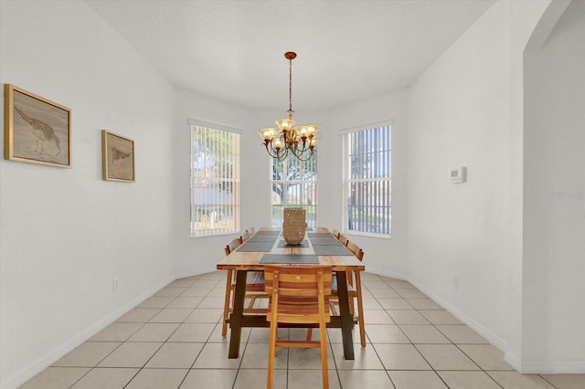 tiled dining room featuring a chandelier