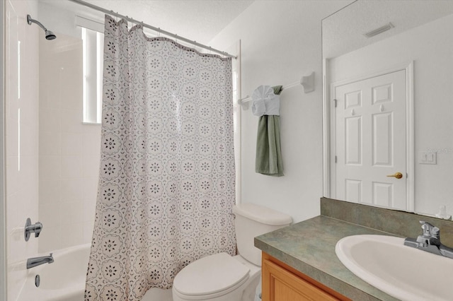 full bathroom featuring vanity, toilet, a textured ceiling, and shower / bath combo