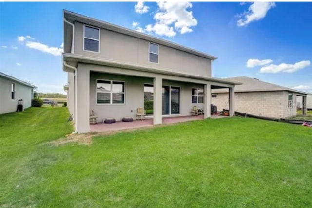 rear view of house featuring a patio area and a lawn