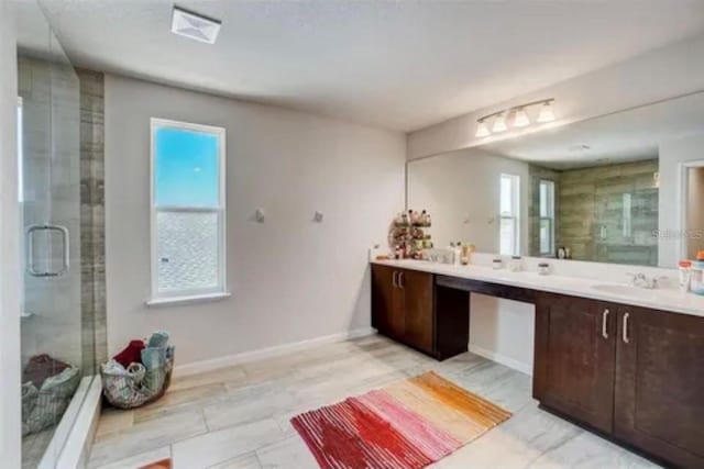 bathroom with vanity and a shower with shower door