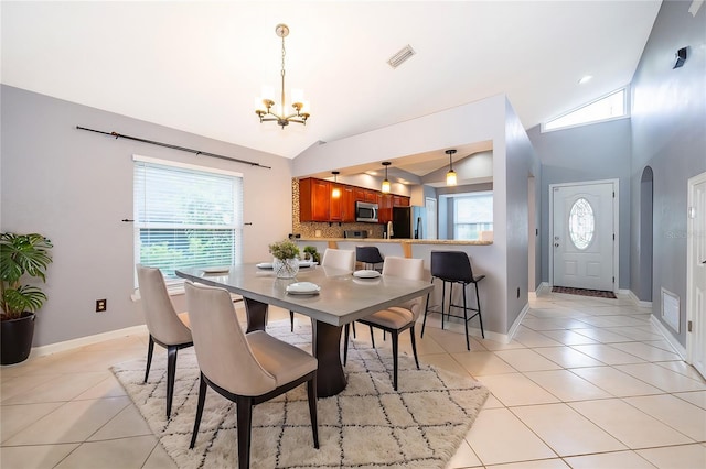 dining space with light tile patterned flooring, vaulted ceiling, and a wealth of natural light